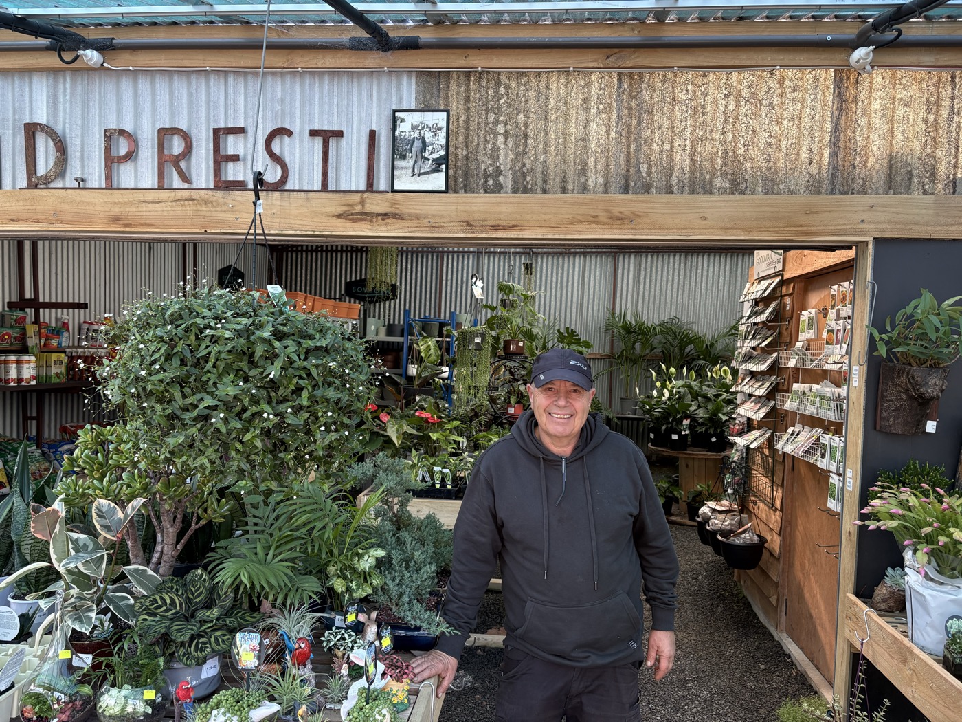 Domenic Presti smiling in his nursery under the iconic D. Presti sign